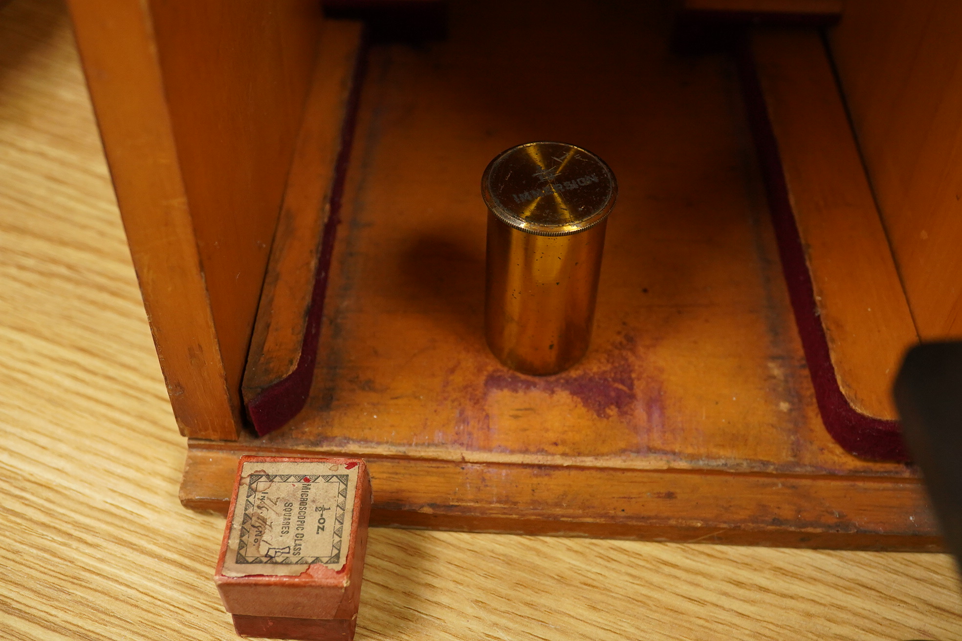 An early 20th century teak cased Ernst Leitz, Wetzlar brass and cast iron monocular microscope, serial no. 268264, with fitted interior to the case and card box of specimen slides, case dimensions; 36cm high, 19cm wide,